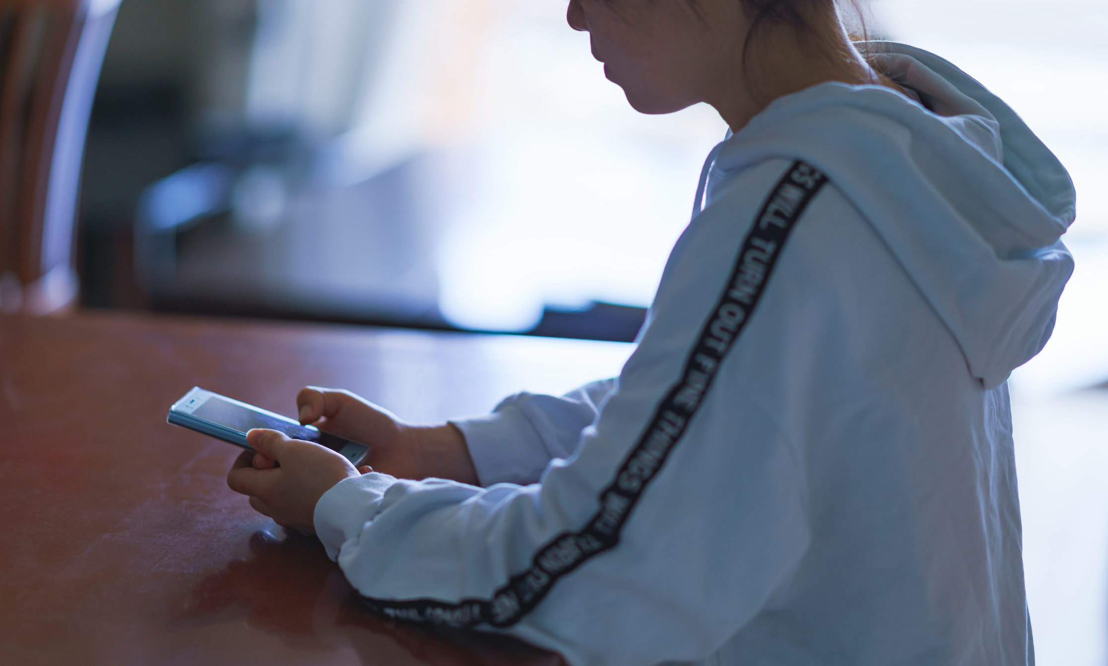 japanese girl playing mobile game at home
